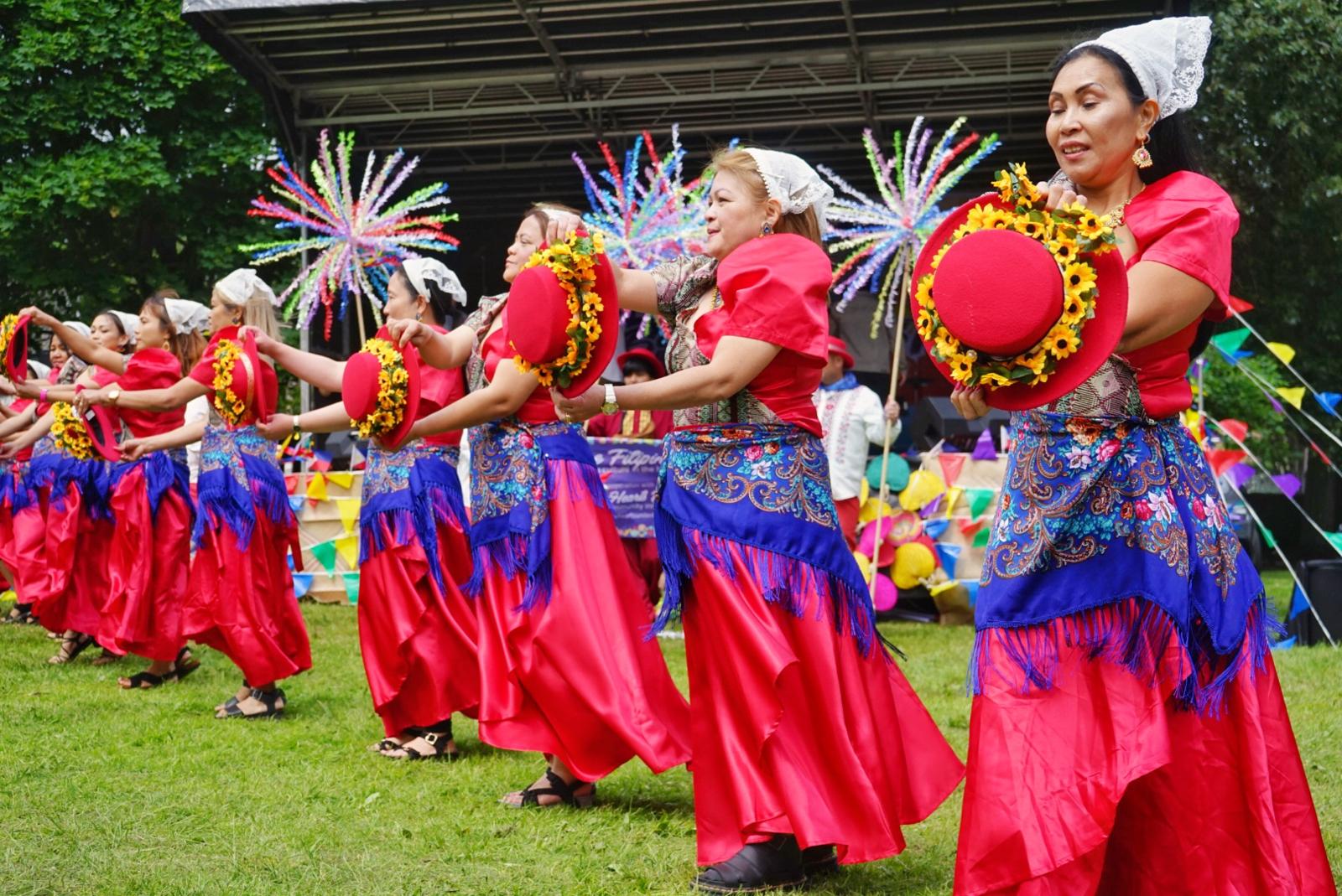 The dancers move in perfect alignment, showcasing the Sibli folk dance with their iconic hand‑held hats.